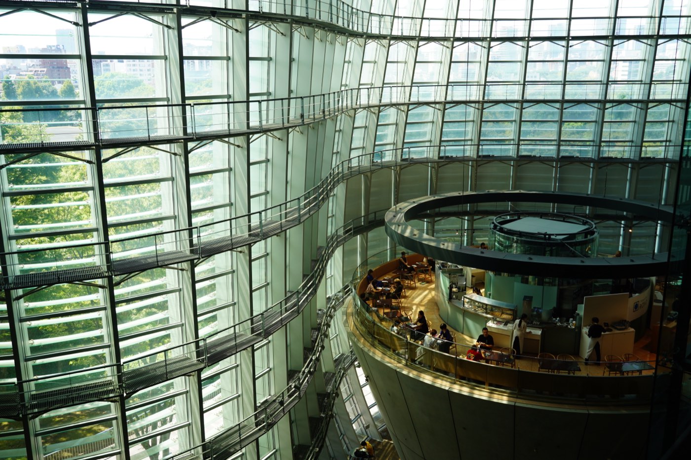 The undulating glass facade and cone-shaped mezzanine inside the National Art Center in Tokyo