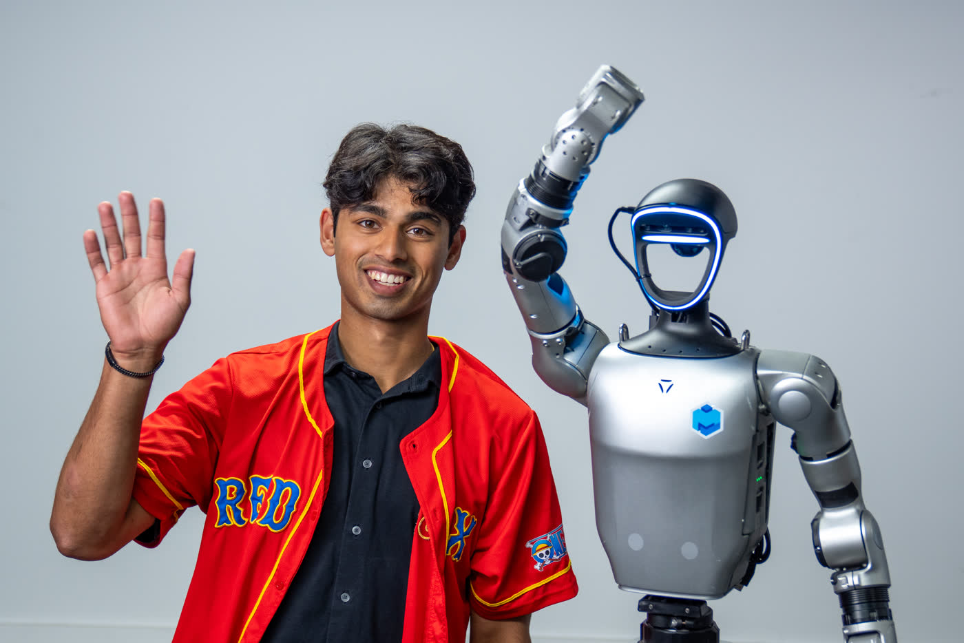 Shrish Choudhary waving beside Frank, a Unitree G1 humanoid robot, at Multiply Labs